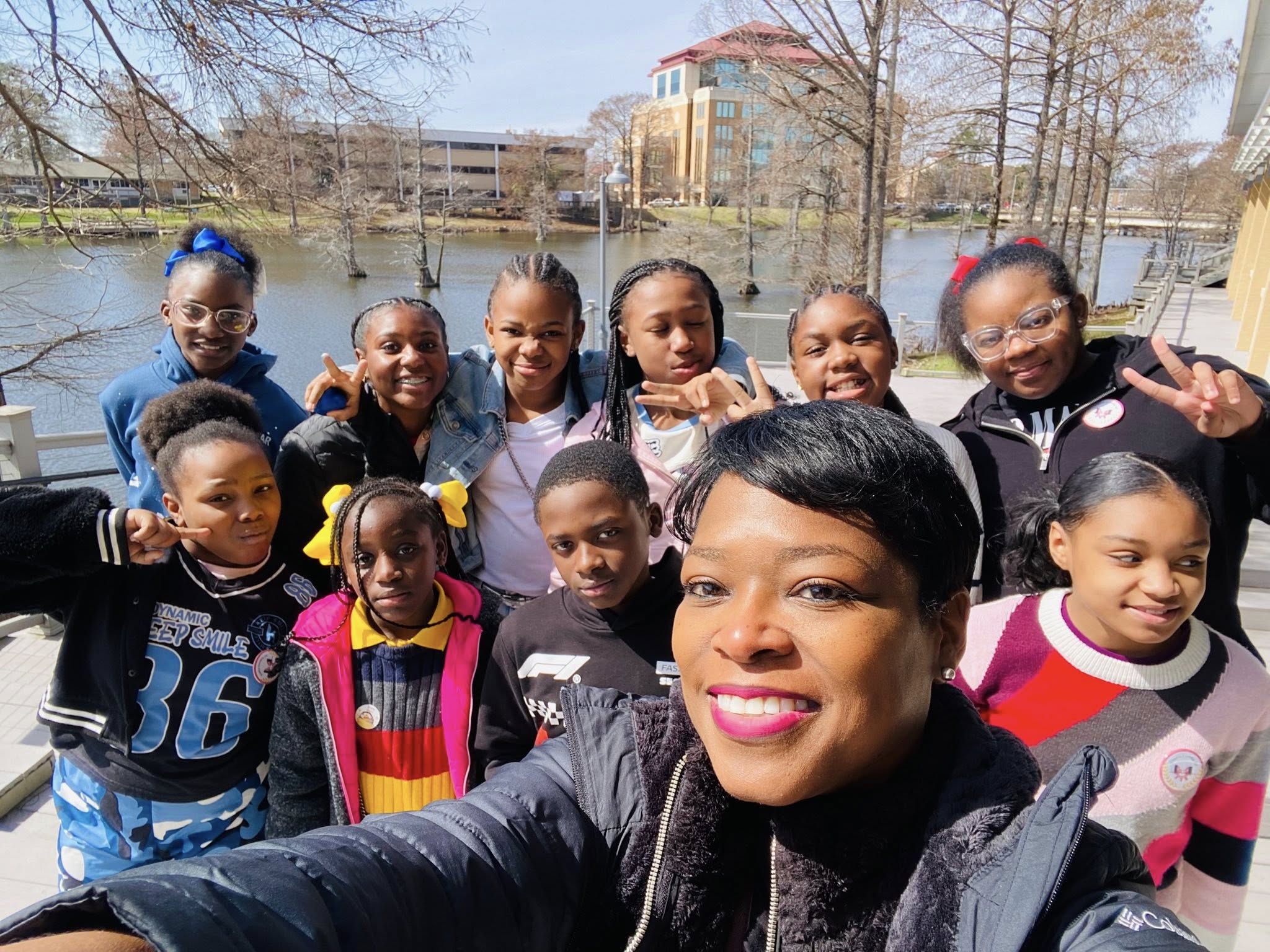 A woman and a group of kids posing for a photo.